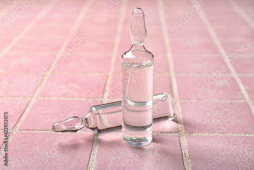Medical ampules on pink til...