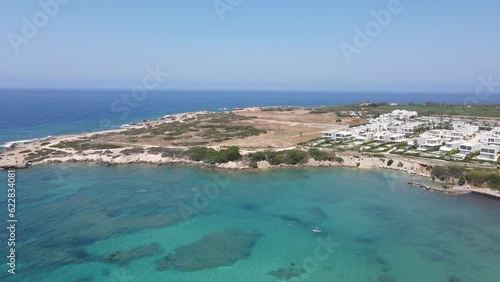 Experience the breathtaking beauty of Coral Beach near Paphos, Cyprus, captured from a stunning aerial perspective. This stock footage showcases the mesmerizing sea, pristine sandy shores, and maje