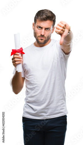 Young handsome man holding degree over isolated background with angry face, negative sign showing dislike with thumbs down, rejection concept