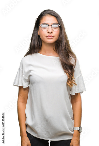 Young beautiful arab woman wearing glasses over isolated background with serious expression on face. Simple and natural looking at the camera.