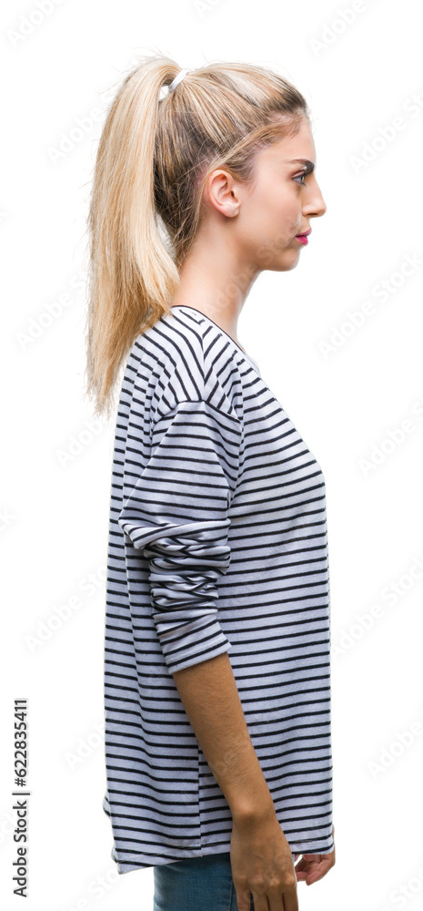 Young beautiful blonde woman wearing stripes sweater over isolated background looking to side, relax profile pose with natural face with confident smile. Young beautiful blonde woman wearing stripes sweater over isolated background looking to side, relax profile pose with natural face with confident smile.