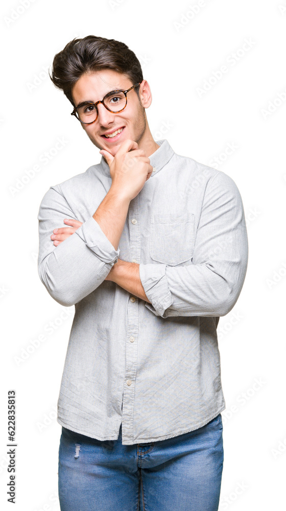Young handsome man wearing glasses over isolated background looking confident at the camera with smile with crossed arms and hand raised on chin. Thinking positive. Young handsome man wearing glasses over isolated background looking confident at the camera with smile with crossed arms and hand raised on chin. Thinking positive.