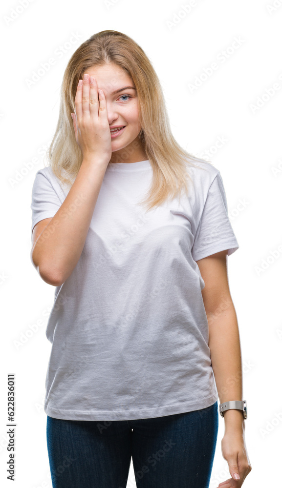 Young caucasian woman over isolated background covering one eye with hand with confident smile on face and surprise emotion. Young caucasian woman over isolated background covering one eye with hand with confident smile on face and surprise emotion.
