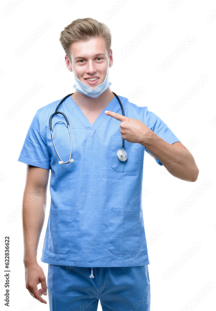 Young handsome blond doctor with surprise face pointing finger to himself Young handsome blond doctor with surprise face pointing finger to himself