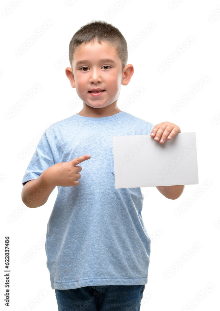 Dark haired little child holding a blank card very happy pointing with hand and finger Dark haired little child holding a blank card very happy pointing with hand and finger