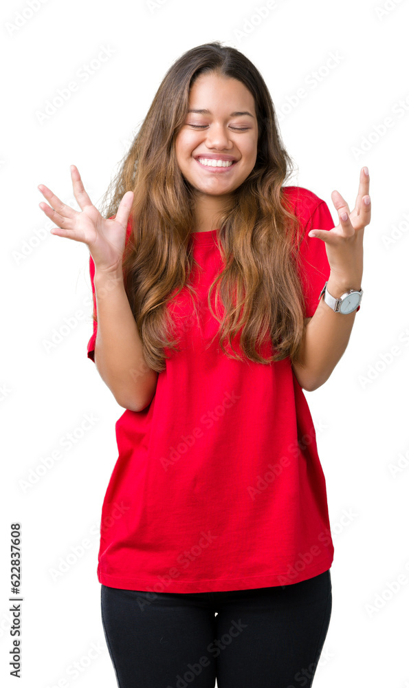 Young beautiful brunette woman wearing red t-shirt over isolated background celebrating mad and crazy for success with arms raised and closed eyes screaming excited. Winner concept Young beautiful brunette woman wearing red t-shirt over isolated background celebrating mad and crazy for success with arms raised and closed eyes screaming excited. Winner concept
