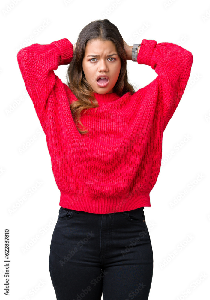 Young beautiful brunette woman wearing red winter sweater over isolated background Crazy and scared with hands on head, afraid and surprised of shock with open mouth
