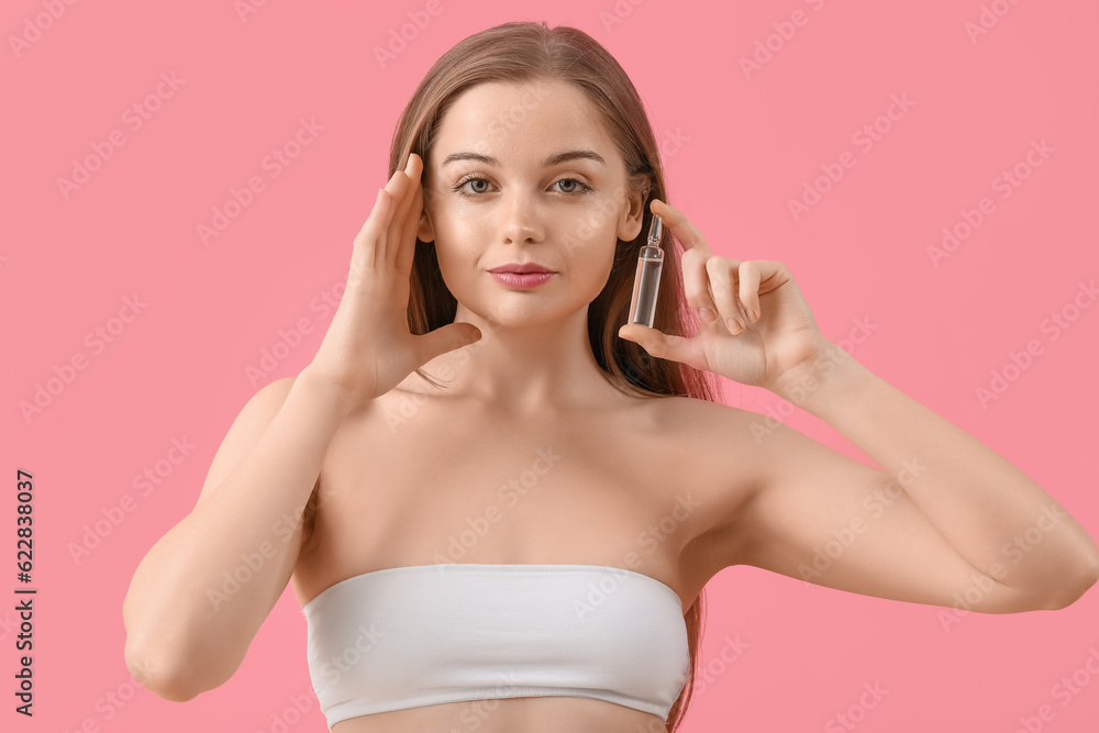 Beautiful young woman with ampule on pink background. Skin care concept Beautiful young woman with ampule on pink background. Skin care concept