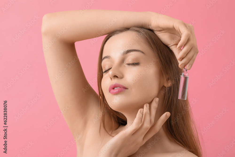 Beautiful young woman with ampule on pink background. Skin care concept Beautiful young woman with ampule on pink background. Skin care concept