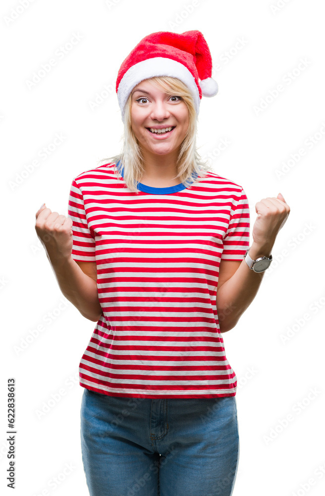 Young beautiful blonde woman wearing christmas hat over isolated background celebrating surprised and amazed for success with arms raised and open eyes. Winner concept. Young beautiful blonde woman wearing christmas hat over isolated background celebrating surprised and amazed for success with arms raised and open eyes. Winner concept.