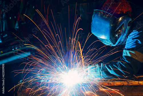 Person with welding shield using the machine