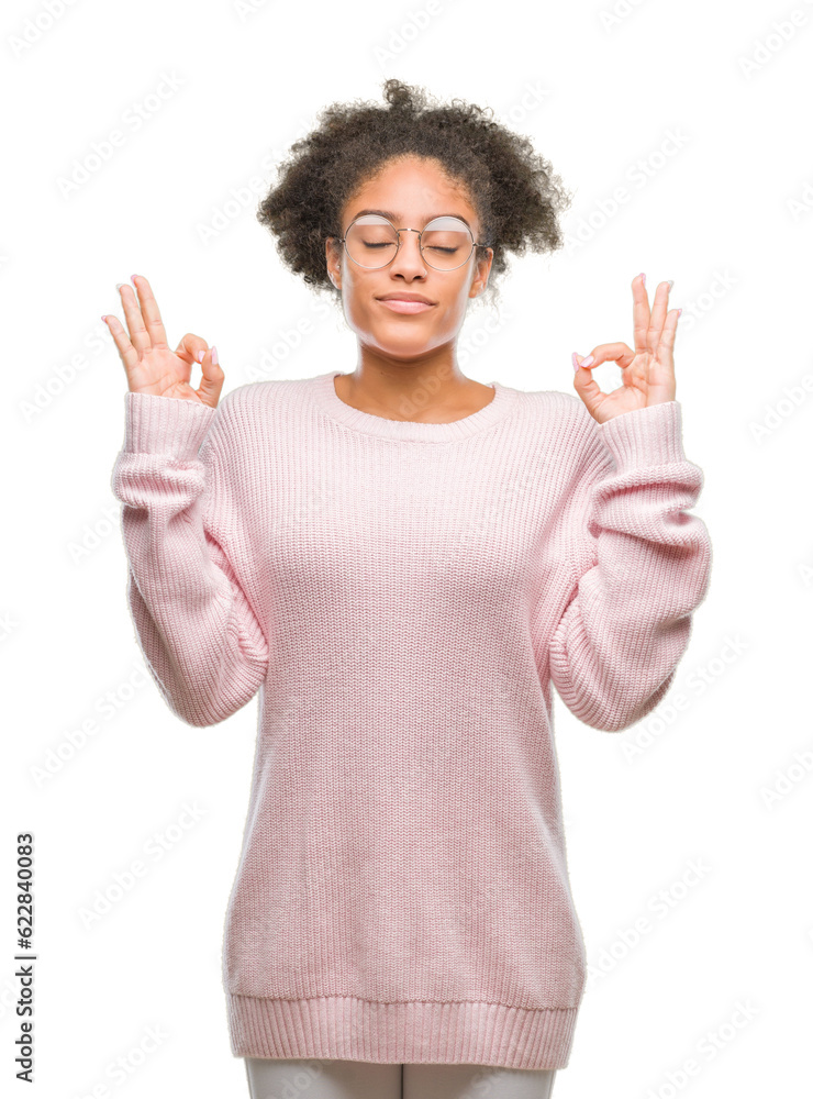 Young afro american woman wearing glasses over isolated background relax and smiling with eyes closed doing meditation gesture with fingers. Yoga concept. Young afro american woman wearing glasses over isolated background relax and smiling with eyes closed doing meditation gesture with fingers. Yoga concept.