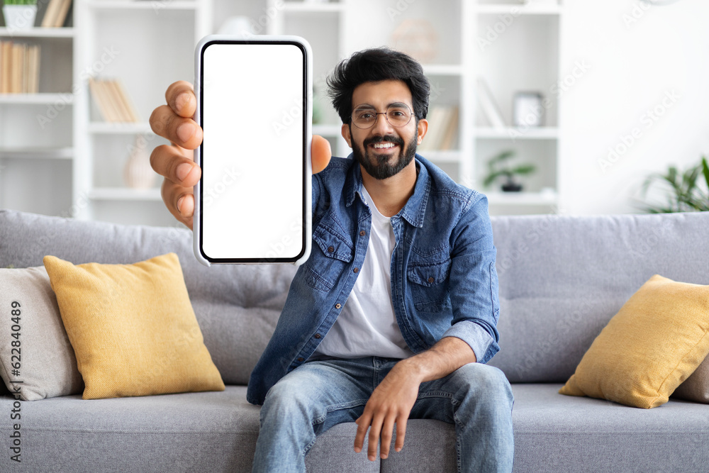 Mobile Ad. Happy Indian Man Demonstrating Blank Smartphone With Big White Screen Mobile Ad. Happy Indian Man Demonstrating Blank Smartphone With Big White Screen