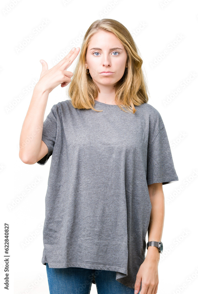 Fototapeta premium Beautiful young woman wearing oversize casual t-shirt over isolated background Shooting and killing oneself pointing hand and fingers to head, suicide gesture.