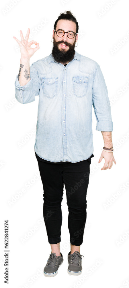 Young hipster man with long hair and beard wearing glasses smiling positive doing ok sign with hand and fingers. Successful expression. Young hipster man with long hair and beard wearing glasses smiling positive doing ok sign with hand and fingers. Successful expression.