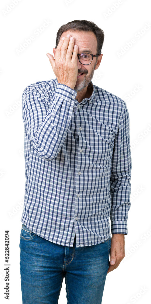 Handsome middle age elegant senior business man wearing glasses over isolated background covering one eye with hand with confident smile on face and surprise emotion. Handsome middle age elegant senior business man wearing glasses over isolated background covering one eye with hand with confident smile on face and surprise emotion.