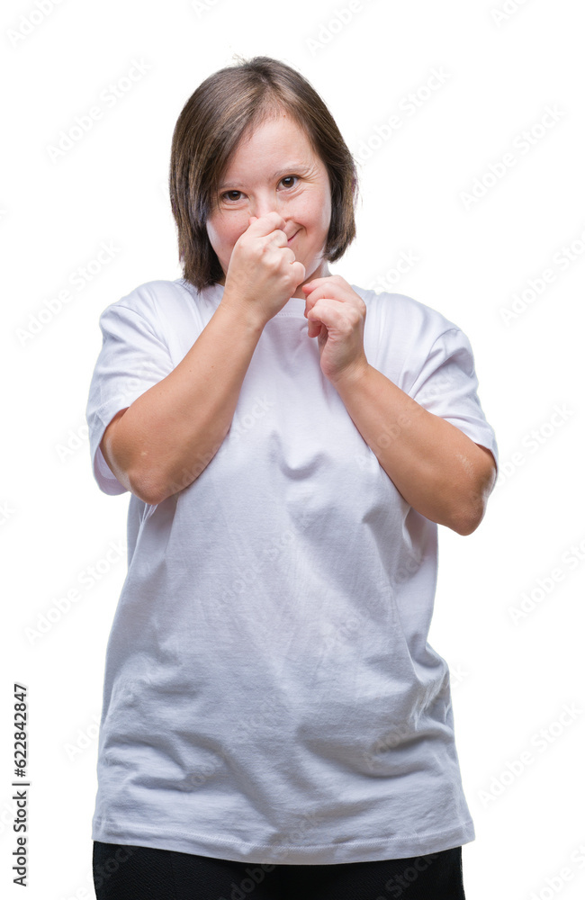 Young adult woman with down syndrome over isolated background smelling something stinky and disgusting, intolerable smell, holding breath with fingers on nose. Bad smells concept. Young adult woman with down syndrome over isolated background smelling something stinky and disgusting, intolerable smell, holding breath with fingers on nose. Bad smells concept.