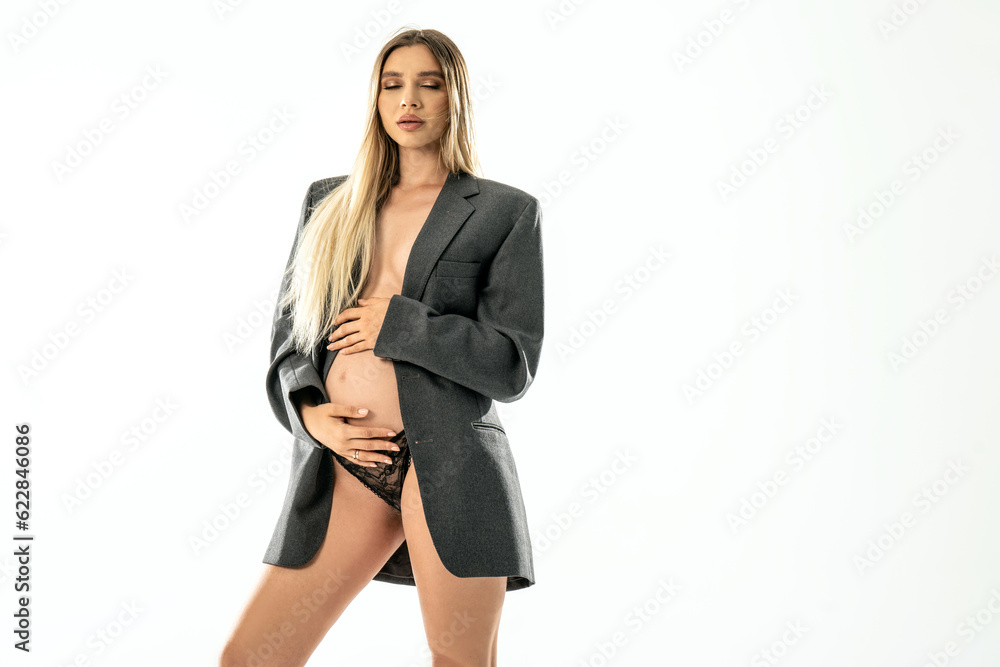 Portrait of beautiful pregnant young woman posing on the white studio background with closed eyes, touching belly. Portrait of beautiful pregnant young woman posing on the white studio background with closed eyes, touching belly.