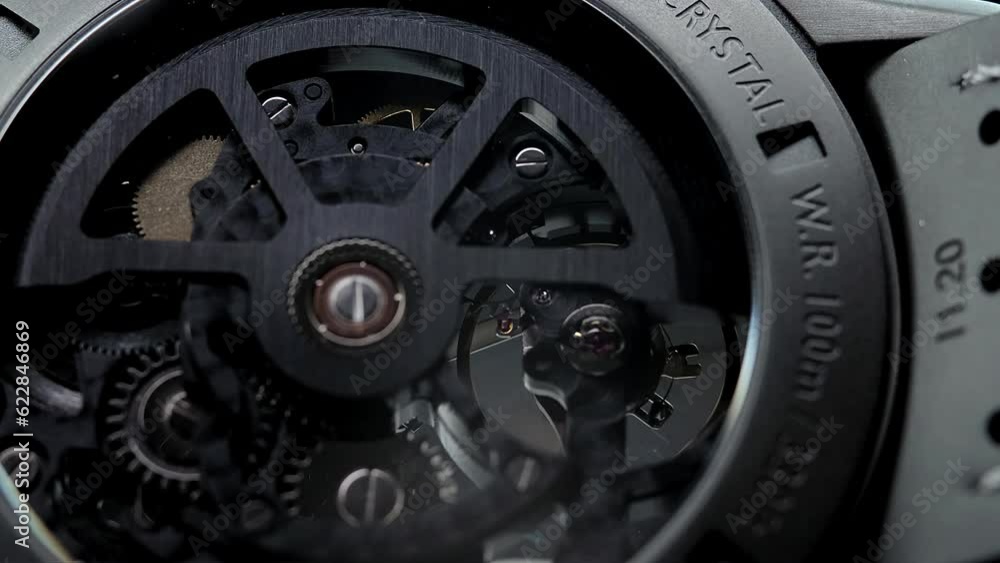 Mechanical watches with gears and cogs. Watch or clock mechanism. Mechanical skeleton watch. Clockwork details and parts.Clock gears running with dramatic flickering light.Open balance extreme closeup Mechanical watches with gears and cogs. Watch or clock mechanism. Mechanical skeleton watch. Clockwork details and parts.Clock gears running with dramatic flickering light.Open balance extreme closeup