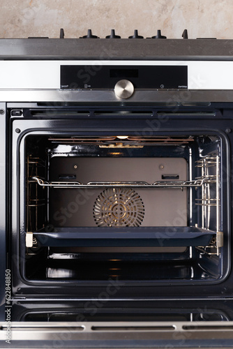 Built-in electric oven with self-cleaning back in the kitchen, door open.