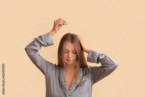 Young woman using cosmetic ...