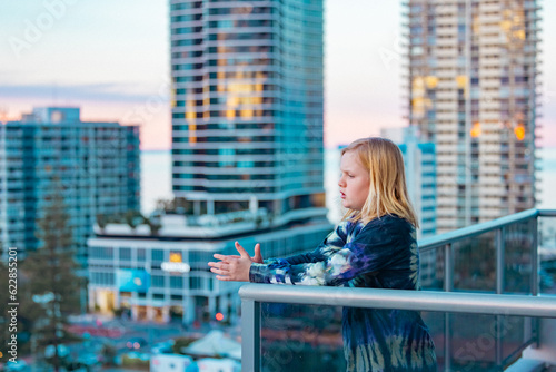 Boy standing on balcony admiring the view from a highrise apartment in Surfers Paradise on the Gold Coast, Queensland Australia