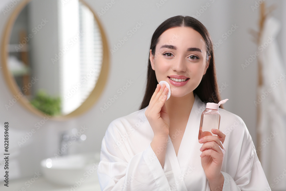 Beautiful woman removing makeup with cotton pad indoors Beautiful woman removing makeup with cotton pad indoors