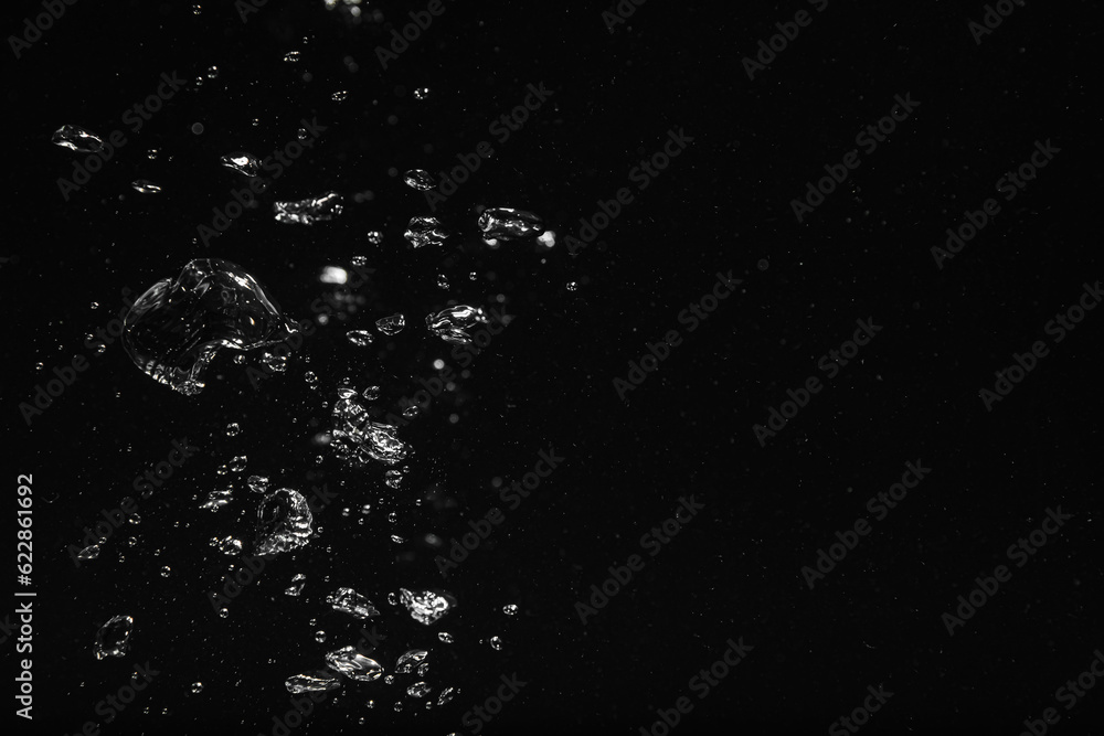 Fototapeta premium Air bubbles in water on black background, space for text