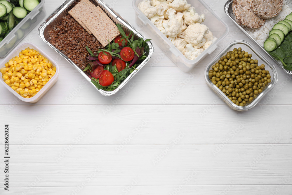 Different containers with fresh products on white wooden table, flat lay. Space for text Different containers with fresh products on white wooden table, flat lay. Space for text