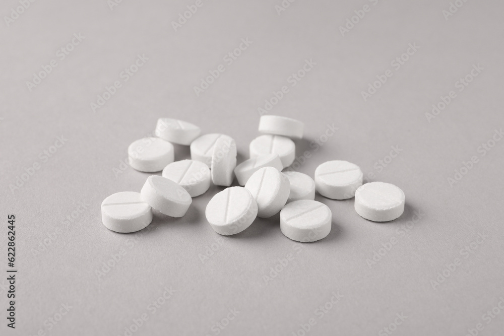 Pile of round pills on light grey background