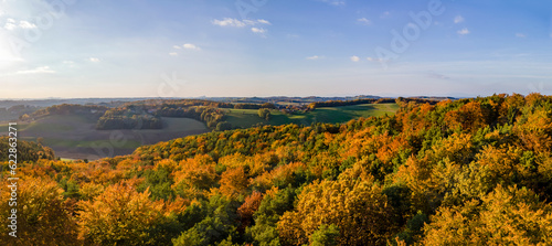 Aerial drone panoramic view of the autumn tree colors as the sun sets on the border of Burgenland and Styria in Austria under scattered clouds. photo