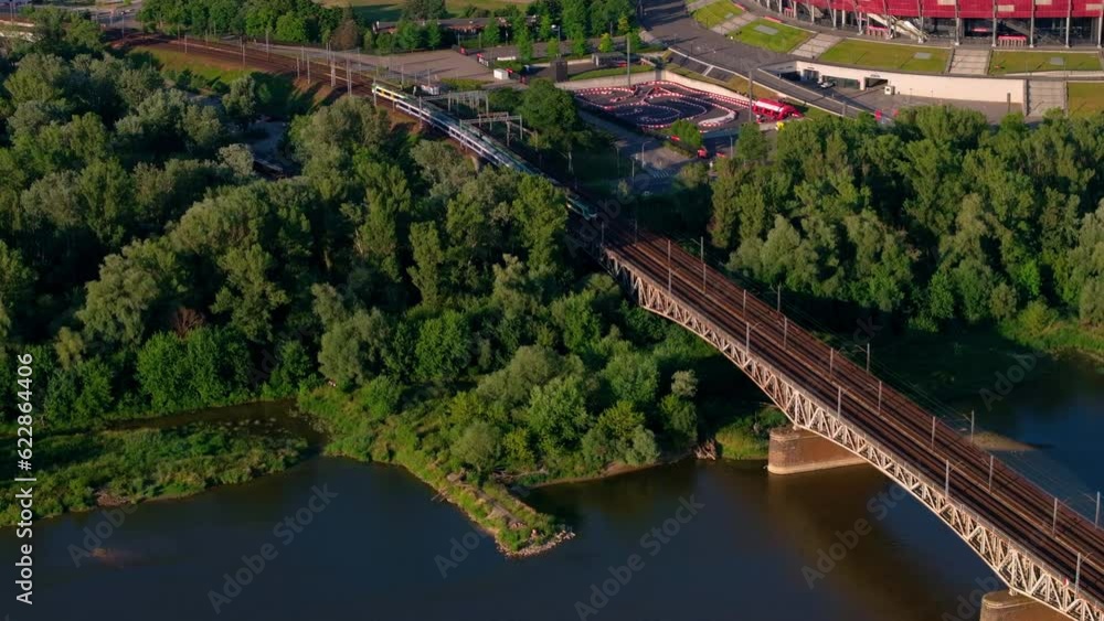 Aerial city view, drone shot of trains passing by the bridge over the Vistula river in Warszawa (Warsaw, Poland). Train heading into the city center of Warsaw in Poland. Aerial city view, drone shot of trains passing by the bridge over the Vistula river in Warszawa (Warsaw, Poland). Train heading into the city center of Warsaw in Poland.