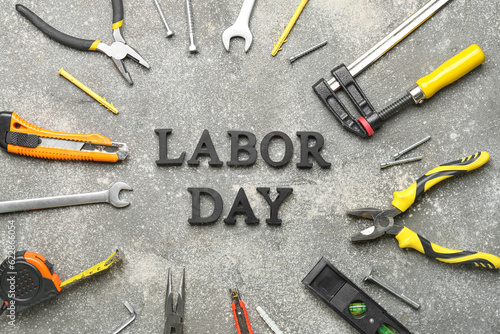 Text LABOR DAY and different tools on grunge grey background