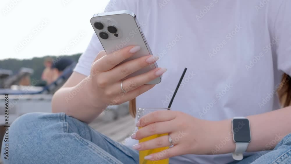 Millenial girl using smartphone on beach sea on sunset. Always connected generation communicate via internet. Millenial girl using smartphone on beach sea on sunset. Always connected generation communicate via internet.