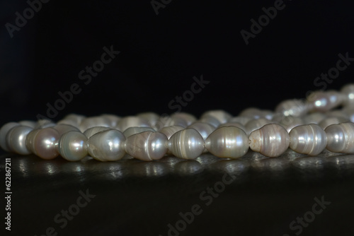 Real pearls Selected, beautiful color, laying on the ground, with reflection.