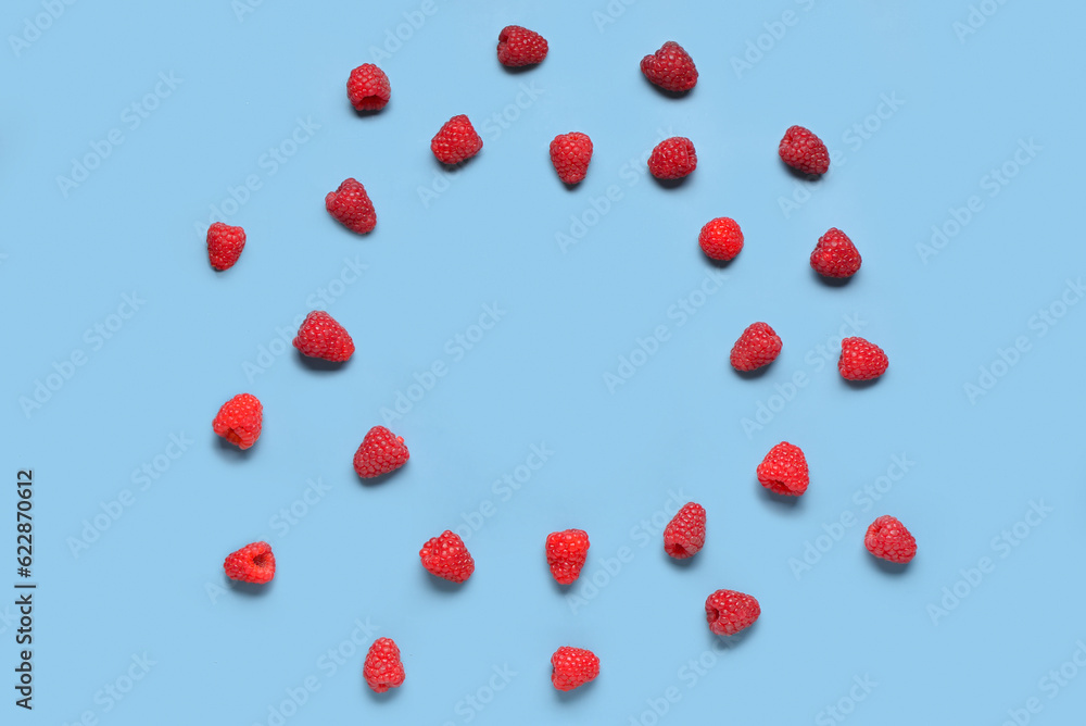 Frame made of fresh raspberries on blue background Frame made of fresh raspberries on blue background