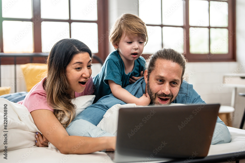 Caucasian attractive family use laptop on bed in the morning at home Caucasian attractive family use laptop on bed in the morning at home