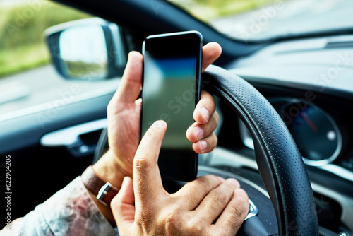 Man using a smart phone while driving a car in the city