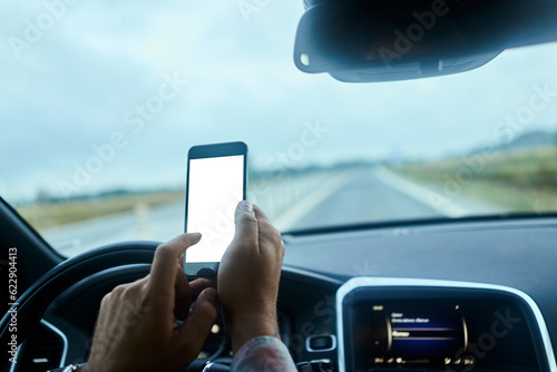 Man using a smart phone while driving a car in the city