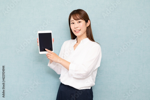 タブレットを持つ女性　白い服
