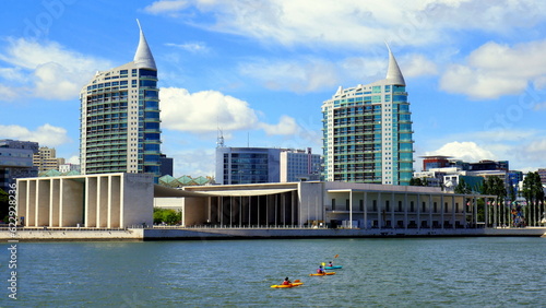 A moderne Gebäude der EXPO 98 in Lissabon am Fluss Tejo mit 3 Paddlern unter blauem Himmel