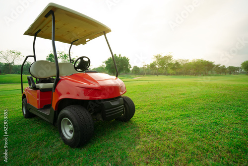 Golf cart in fairway of golf course with green grass field.