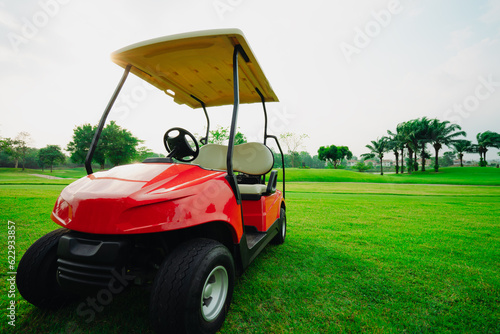 Golf cart in fairway of golf course with green grass field.