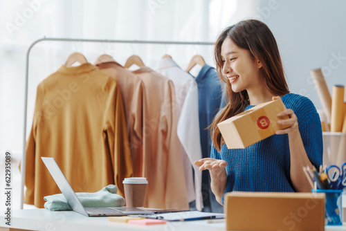 How To Start A Clothing Store Online Business apparel! Young confident asian female fashion owner social media influencer Live selling clothes, new products at home office small business e-commerce.