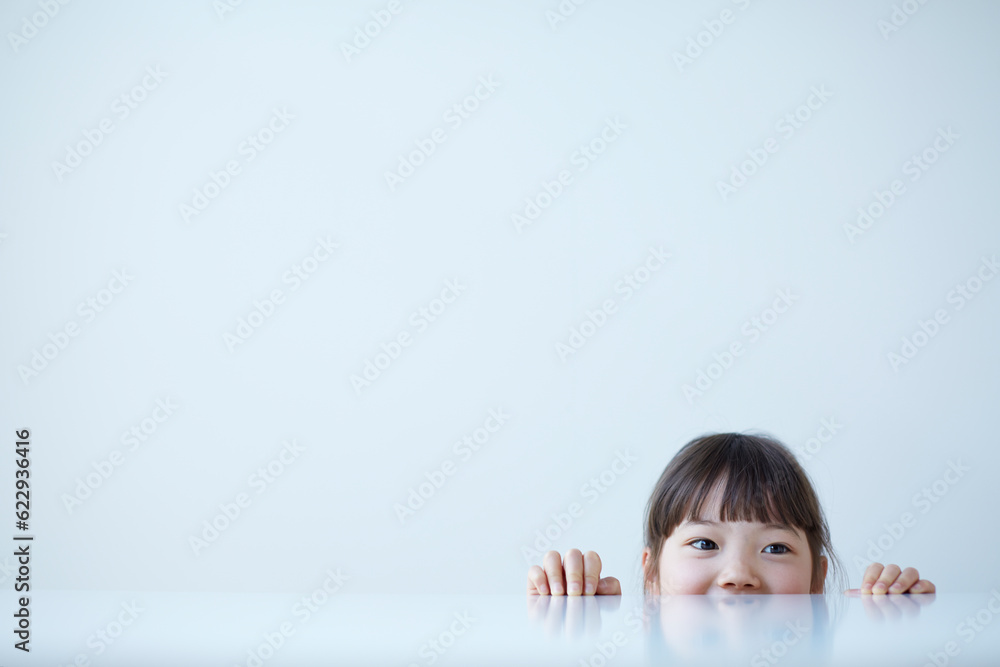 白いテーブルの下から覗く女の子 白いテーブルの下から覗く女の子