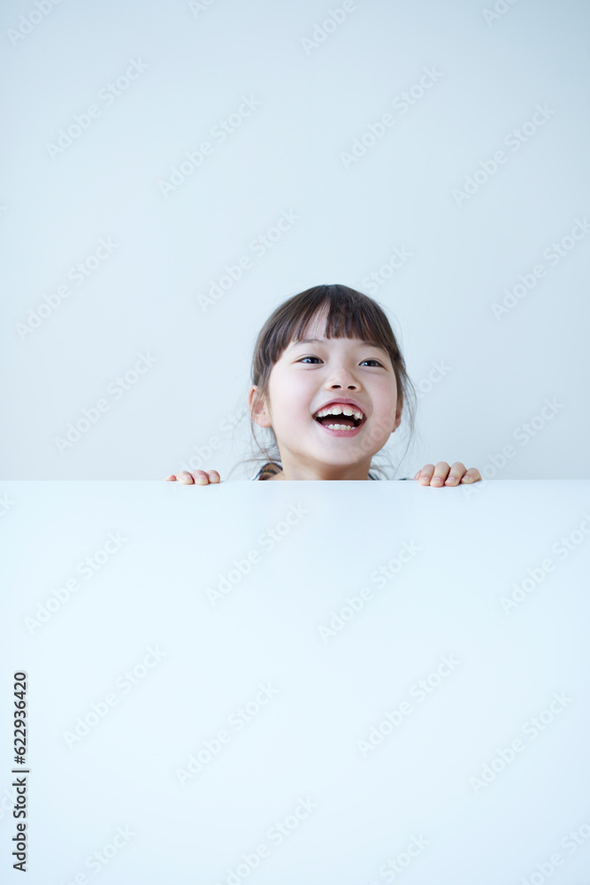 白いテーブルの下から覗く女の子