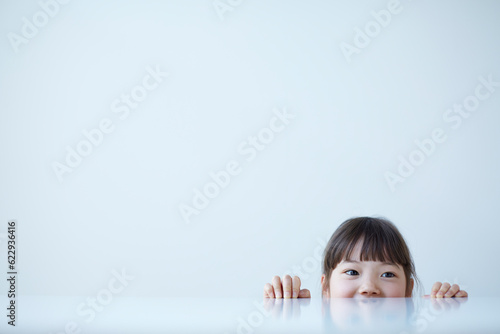 白いテーブルの下から覗く女の子 photo