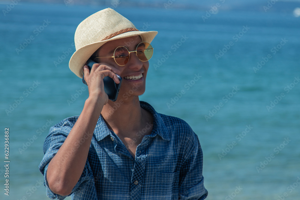 young man on the beach talking on the mobile phone