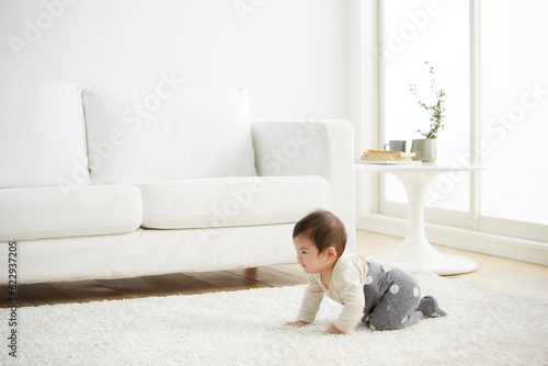 白で統一した部屋ではいはいをする赤ちゃん photo