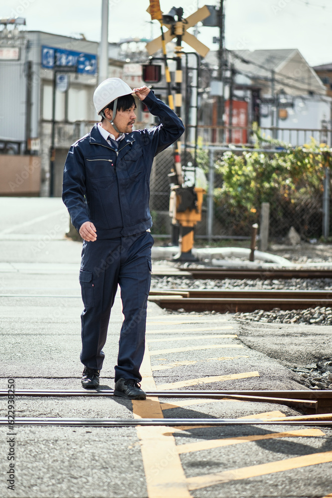 線路を渡る作業服とヘルメットの男性 線路を渡る作業服とヘルメットの男性